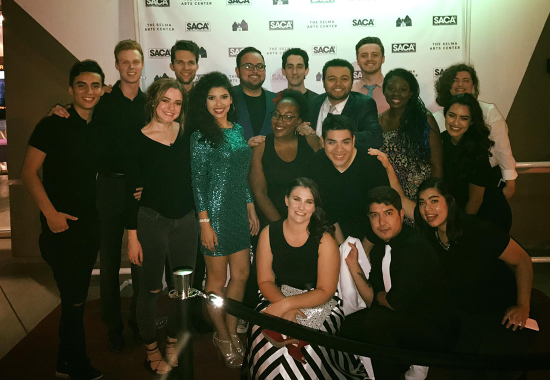 Large group of actors standing in front of a SACA backdrop.